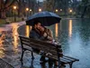 Romantisch stel zit in een park ondanks de regen